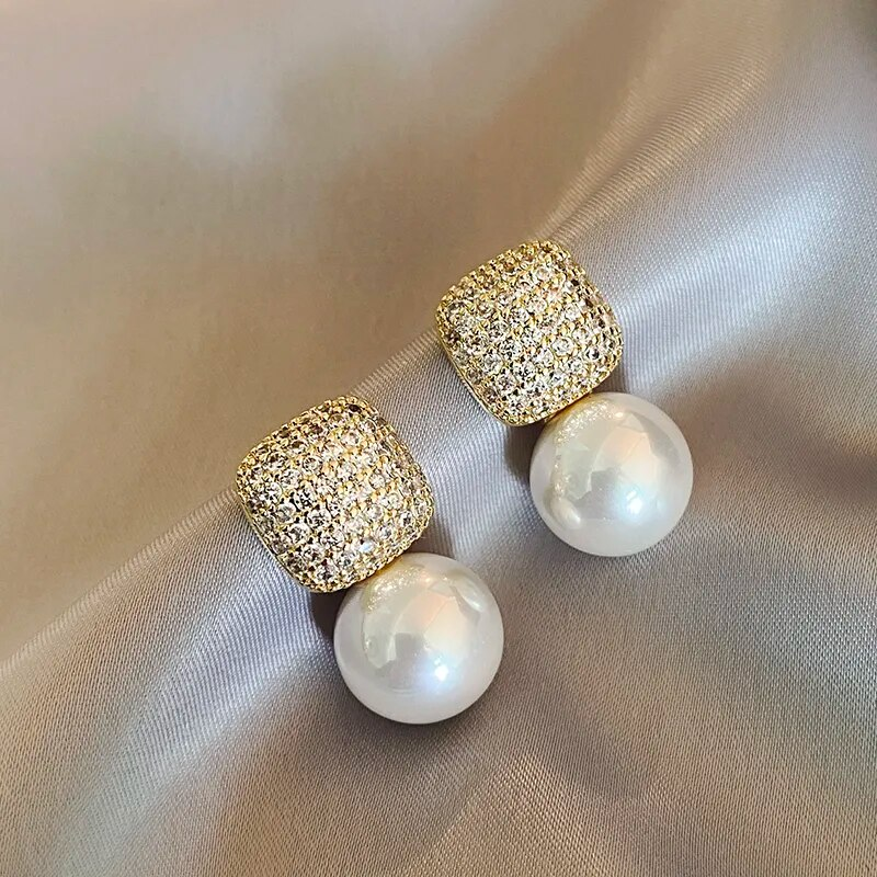 Pendientes elegantes brillantes con perlas.