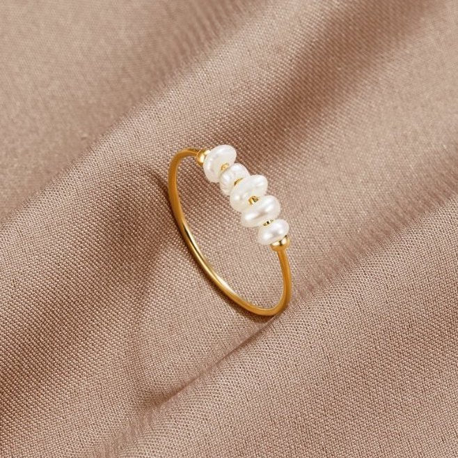 Anillo bañado en oro con elegantes perlas.