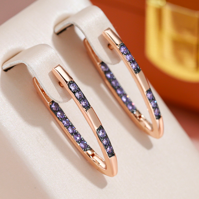Pendientes elegantes en oro con circonitas moradas.