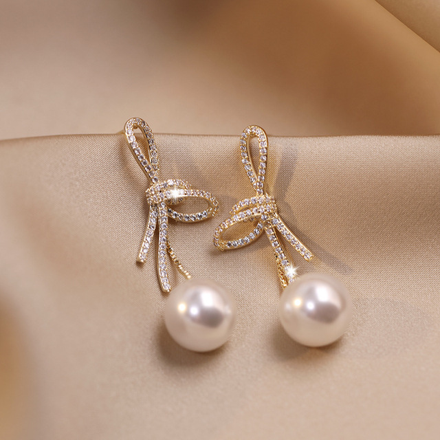 Pendientes de perlas con lazo dorado brillante