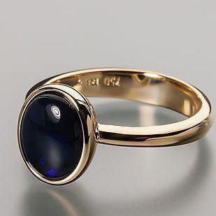 Anillo dorado de cristal oscuro.