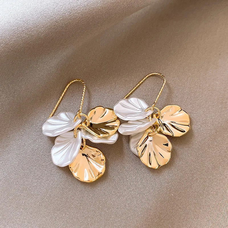 Pendientes elegantes de pétalos blancos y dorados.