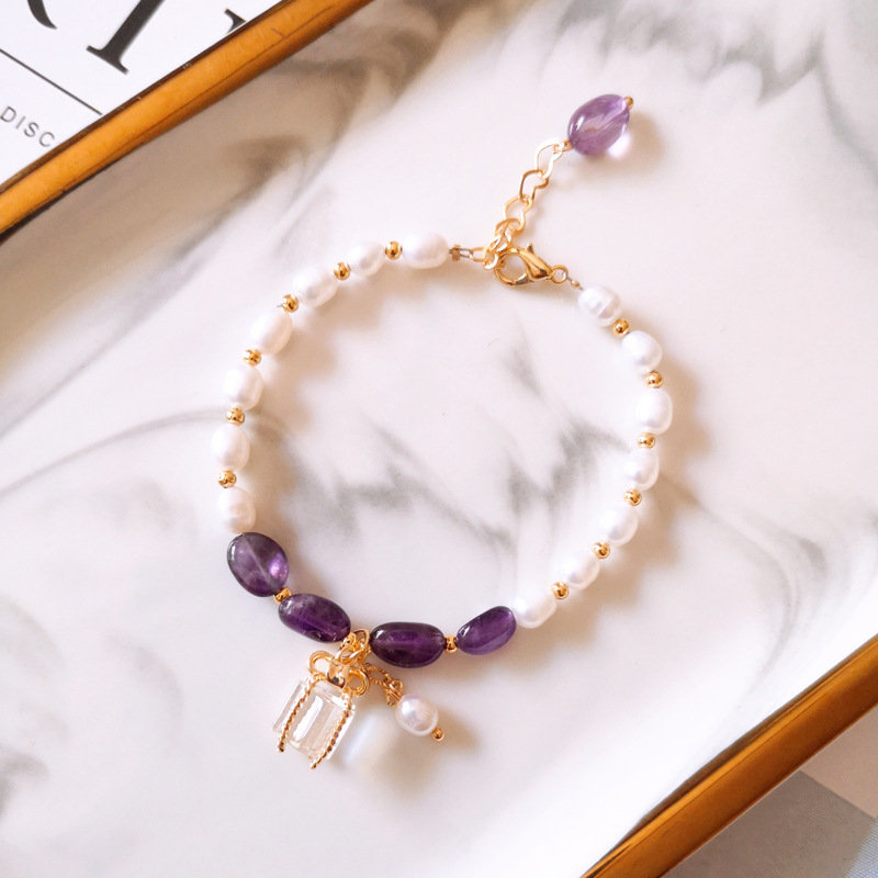 Pulsera con piedras moradas y perlas en oro.